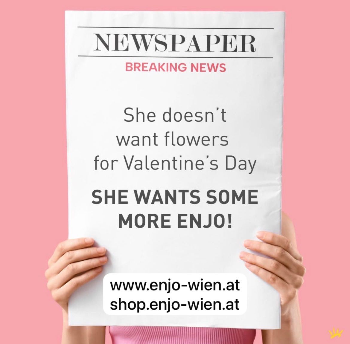A person holds a newspaper with the headline 'Breaking News'. It reads 'She doesn't want flowers for Valentine's Day. She wants some more Enjo!'. Below the headline, there are two website URLs.