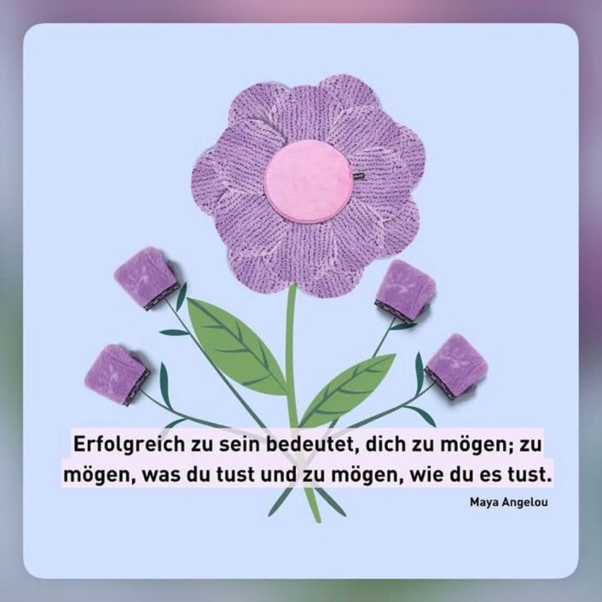A purple knitted flower with pink petals and green leaves with a quote by Maya Angelou on a light blue background.