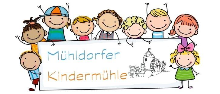 Eine Gruppe von Kindern hält ein Schild mit dem Text 'Mühldorfer Kindermühle'. Sie lächeln und scheinen für ein Foto zu posieren. Einige der Kinder haben Accessoires wie Hüte und Schleifen.
