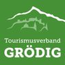 A green background with a mountain silhouette and the words 'Tourismusverband Grodig' in white.