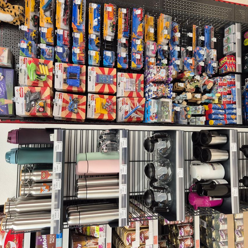 Ein Laden mit einer Vielzahl von Spielzeug und Getränken. Die Spielzeuge sind in verschiedenen Farben und Größen. Die Getränke sind Edelstahlbecher und -flaschen.