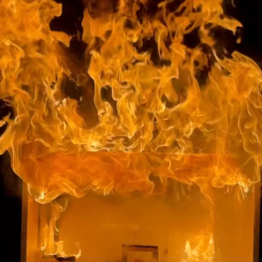 Eine Nahaufnahme von intensivem Feuer mit dickem Rauch, der aufsteigt und ein Objekt in einem feurigen Inferno verzehrt.