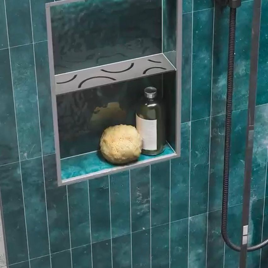 A shower stall with teal tiles and a soap bar on a blue shelf with a glass cover.