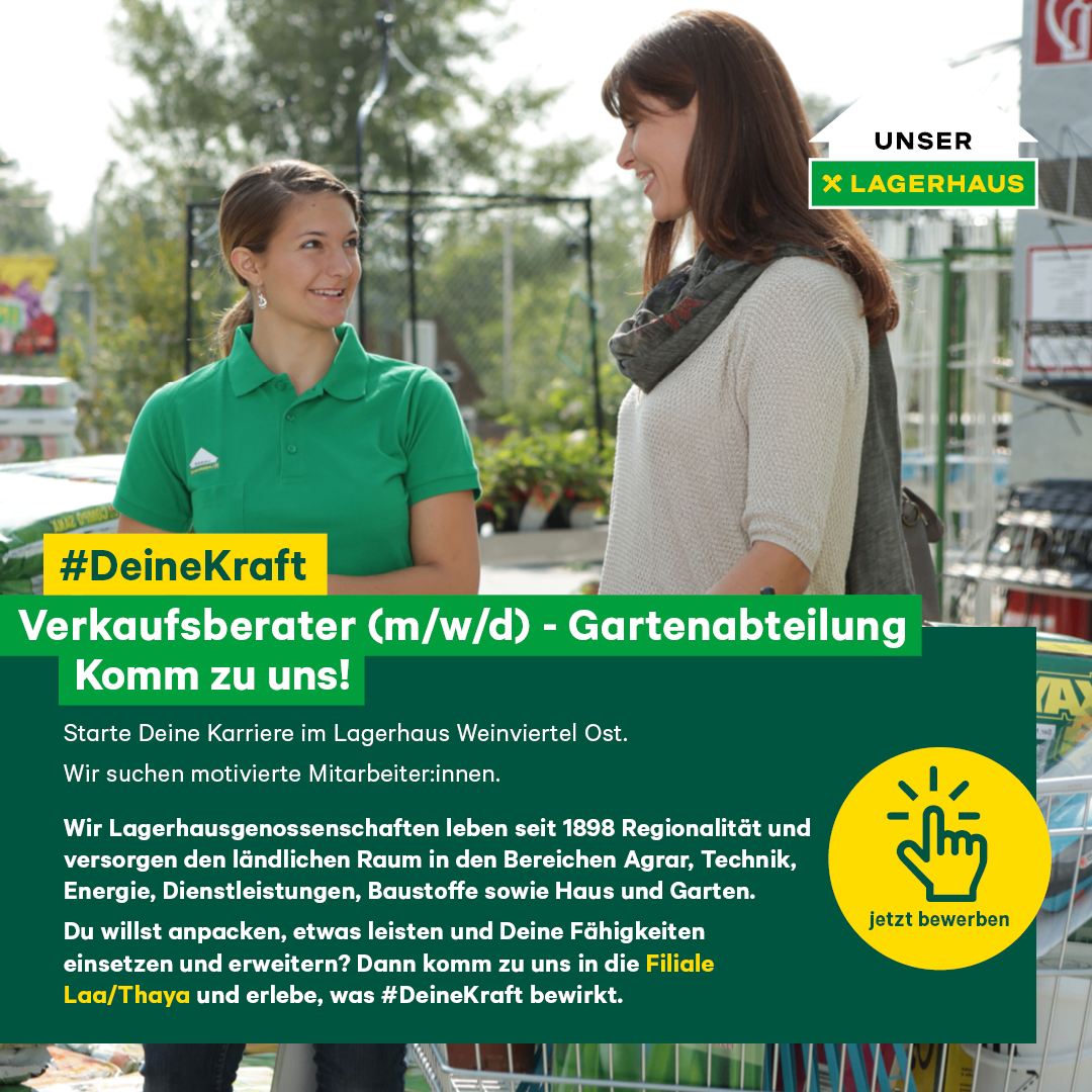 Eine Frau in einem grünen Shirt steht in einem Gartengeschäft und lächelt eine andere Frau in einem grauen Schal an. Das Schild sagt 'Deine Kraft.' Das Geschäft hat ein grünes Banner mit Logo und Text.