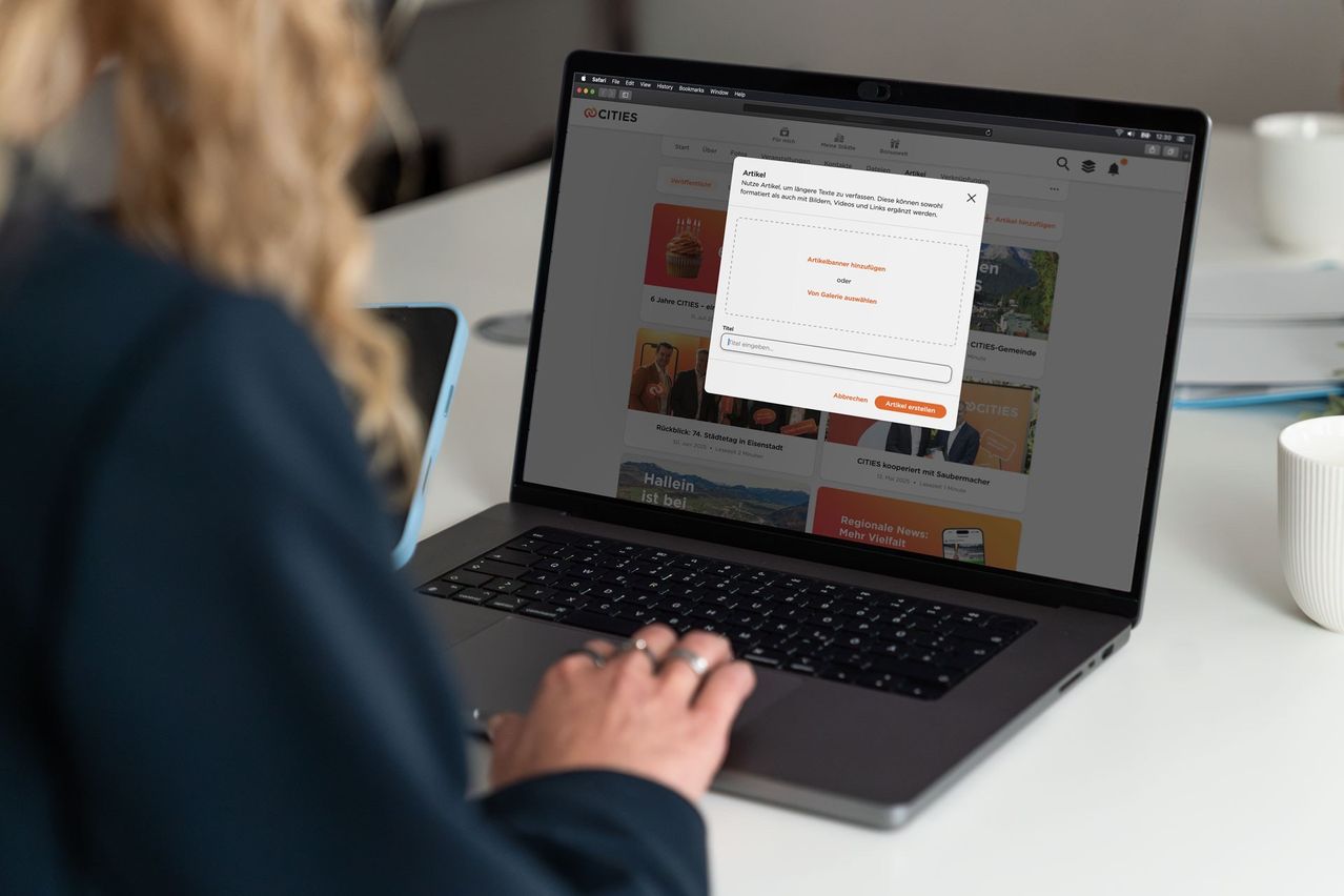 Eine Person arbeitet auf einem Laptop, das die 'CITIES'-Website anzeigt. Eine Pop-up-Nachricht fragt, ob sie einen Artikel speichern möchten.