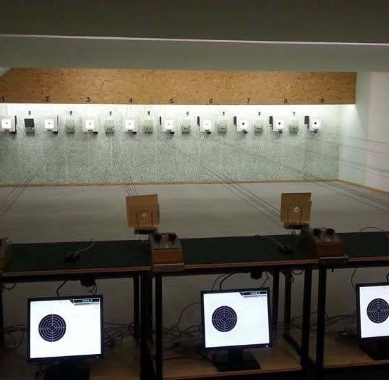 Ein Schießstand mit nummerierten Zielen und Monitoren. Jeder Monitor zeigt ein Ziel mit einem Bullauge.