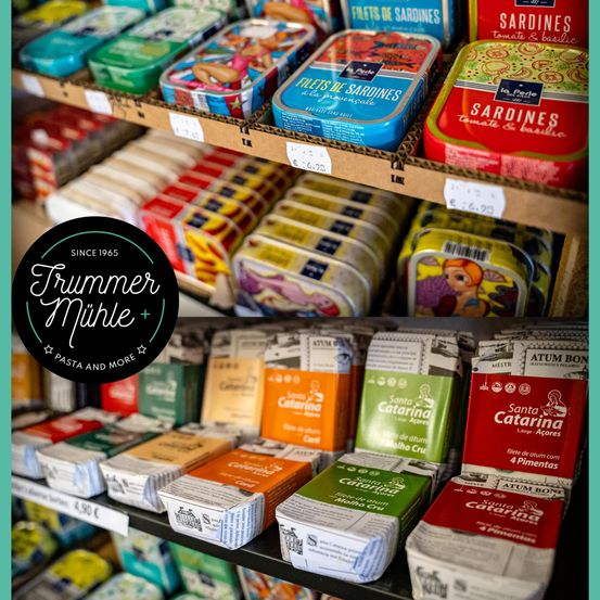 Ein Geschäft zeigt eine Vielzahl verpackter Lebensmittelprodukte, darunter Dosen Sardellen und Packungen von Santa Catarina Produkten, mit sichtbaren Preisschildern.