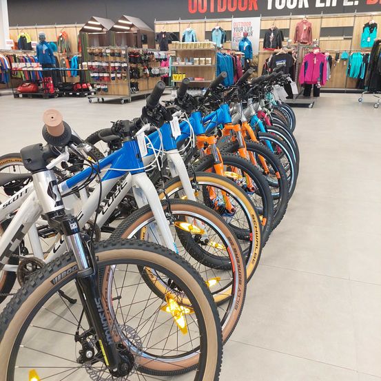 Bild enthält, Person, Glove, Wheel, Indoors, Shop, Vehicle, Bicycle, Hat, Handbag
