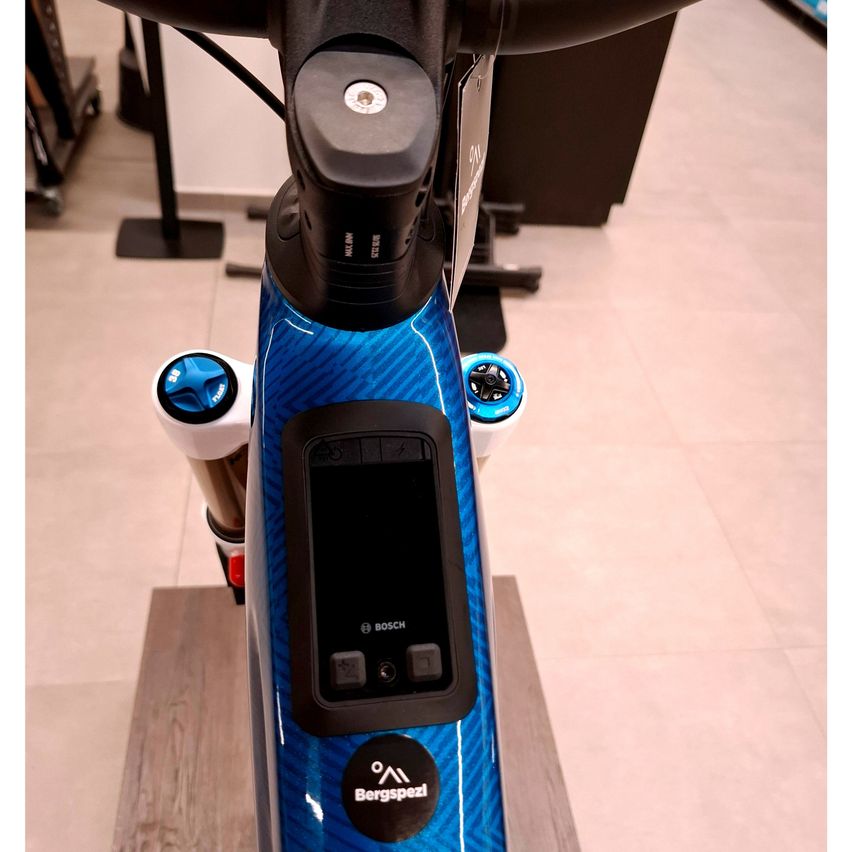 Nahaufnahme eines blau-schwarzen Fahrrads mit Bosch-Display und dem Wort Bergspezial auf der Vorderseite.