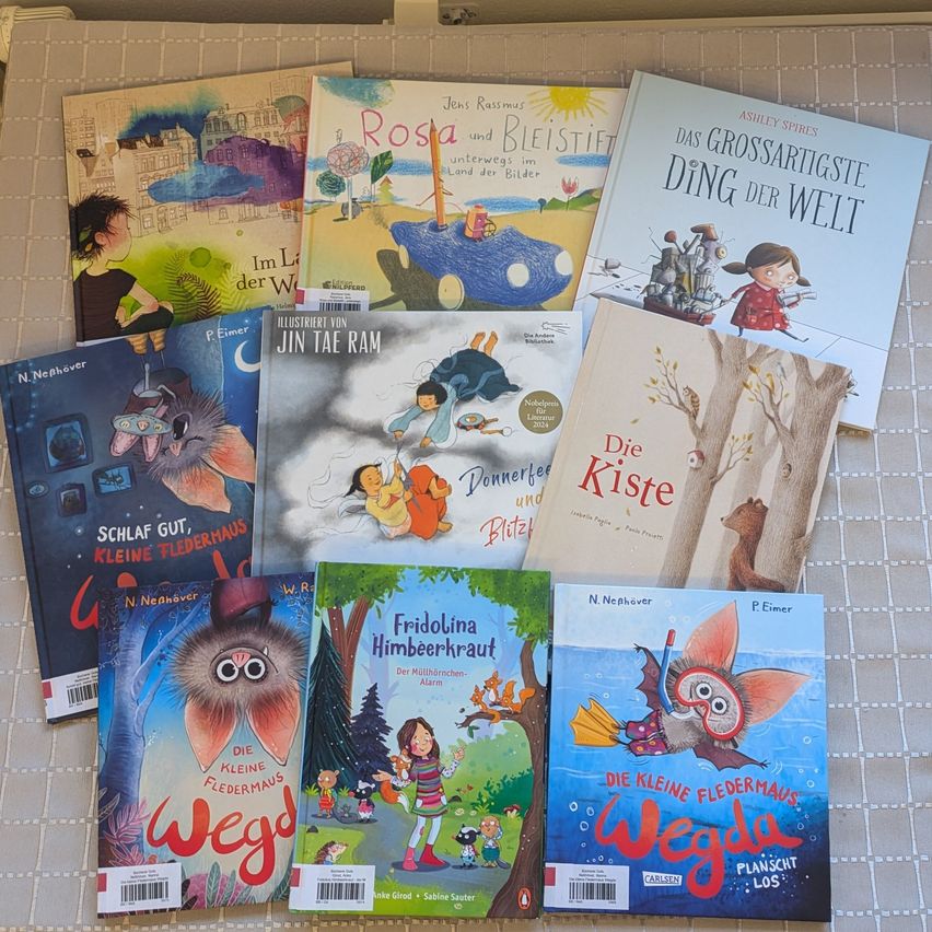 A collection of children's books with colorful illustrations and various titles like 'Rosa', 'The Small Bat', and 'The Most Serious Thing in the World'.