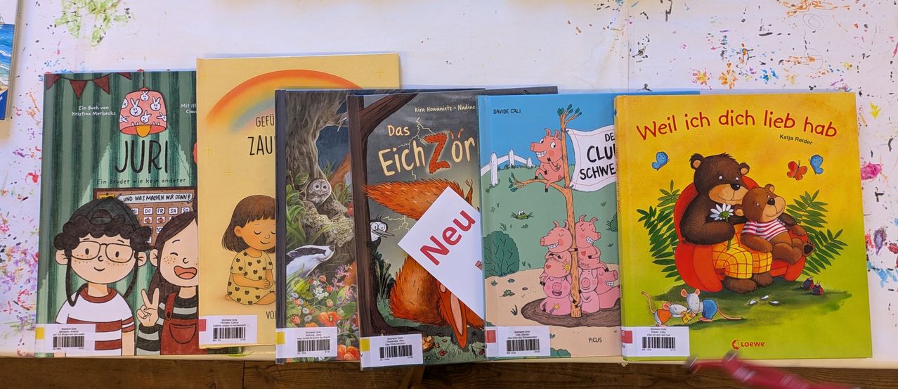 Ein Regal zeigt fünf Kinderbücher. Ein Buch hat ein Etikett mit der Aufschrift 'Neu'. Die Titel sind 'Das Eichhörnchen', 'Vogel', 'Davide Cali' und 'De Club Schwein'.