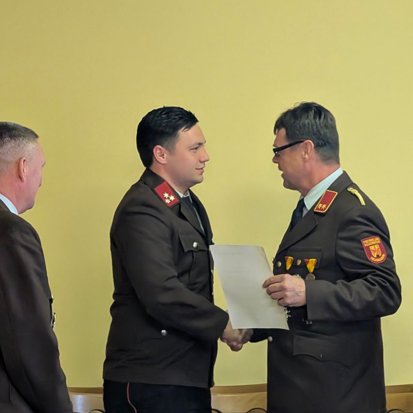 Drei Männer in Militäruniformen stehen in einem Raum, ein Mann hält ein Papier, während die anderen beiden zusehen.