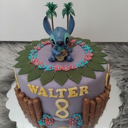 Ein Geburtstagskuchen für Walter mit einer blauen Stitch-Figur, die eine Gitarre spielt, umgeben von bunten Blumen und Palmen. Der Kuchen hat eine lila Basis und braune Akzente.