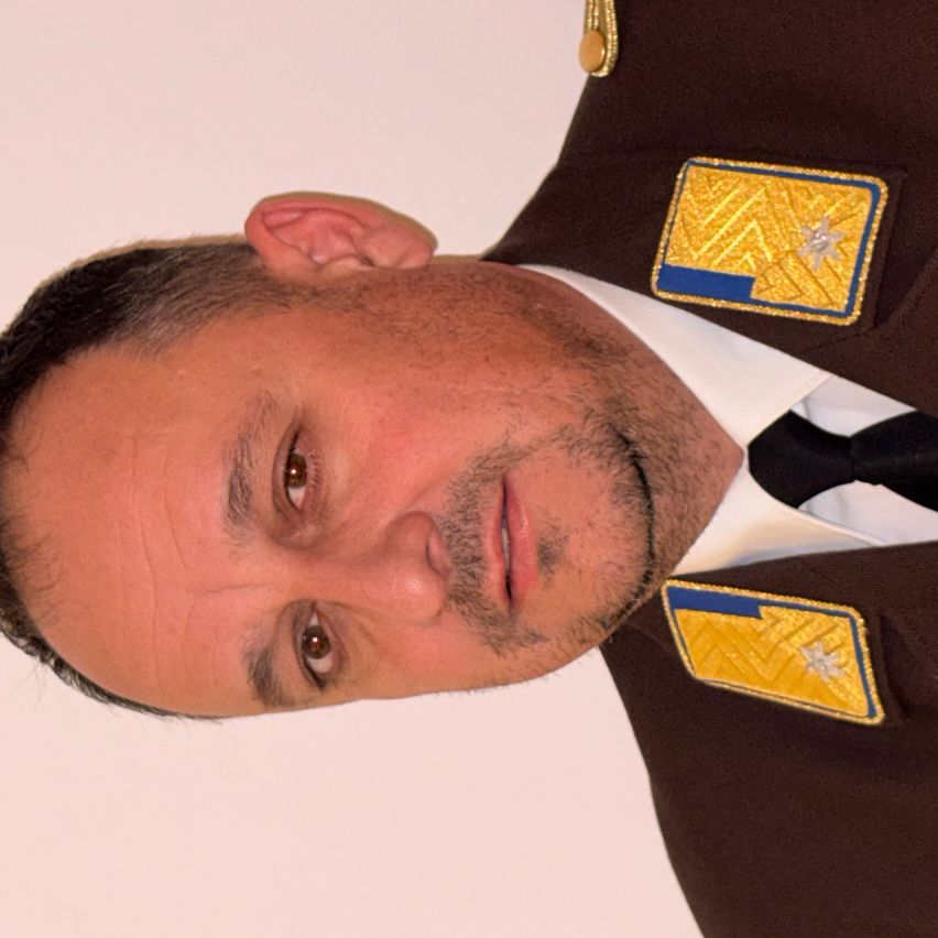 Ein Mann in einem Militäruniform mit einem Sternenabzeichen auf den Schultern, schaut direkt in die Kamera mit einem ernsten Ausdruck.