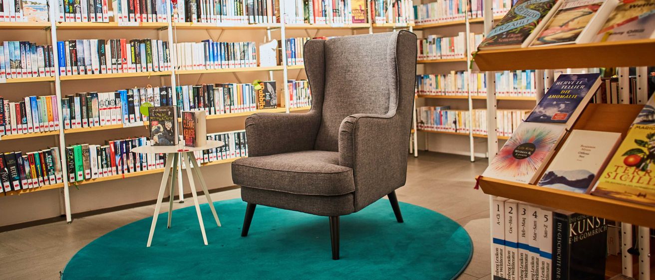 Bild enthält, Book, Indoors, Library, Publication, Furniture, Chair, Rug, Balloon, Bookcase, Person