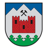 Ein Schild mit einer roten Burg und einem Hammer auf einem Berg, umgeben von einem grünen Rand.
