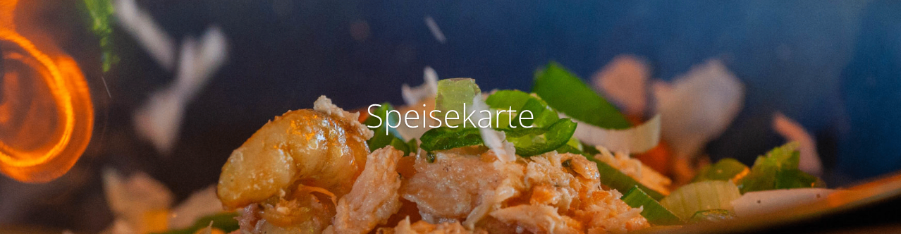 Eine Nahaufnahme eines Meeresfrüchtegerichts mit Garnelen, Fisch und grünem Gemüse. Das Gericht hat eine cremige Textur und ist mit grünen Kräutern garniert.