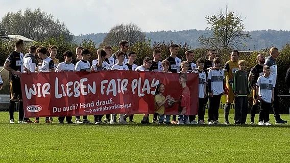 Bild enthält, People, Person, Field, Clothing, Footwear, Shoe, Text, Outdoors