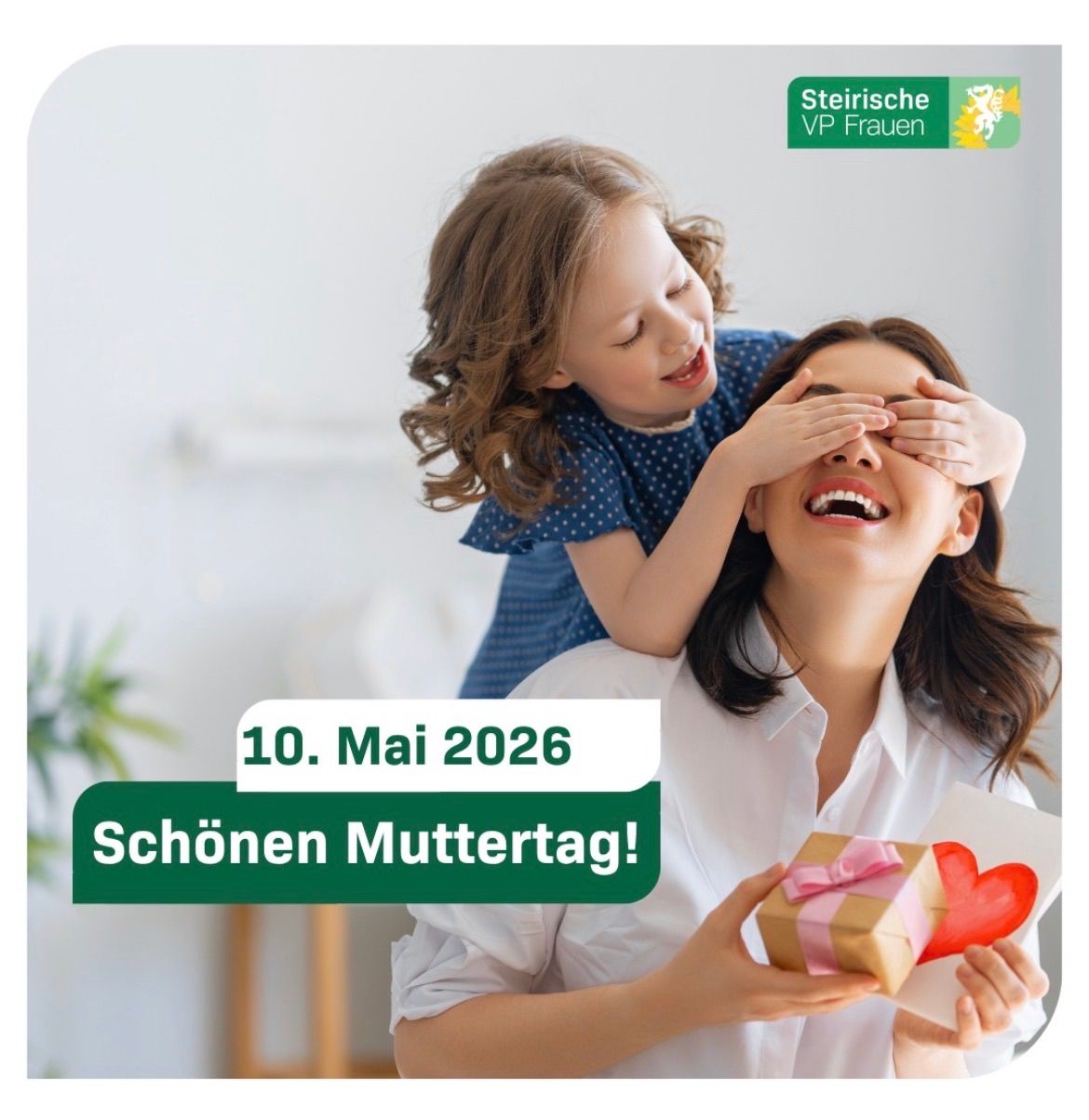 Eine Frau hält eine Geschenkbox mit einem Herz darauf, während ein Mädchen hinter ihr lugt. Das Datum 10. Mai 2026 ist angezeigt. Der Text lautet 'Schönen Muttertag!'