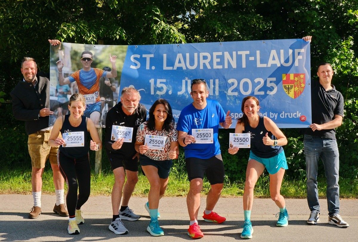 Fünf Läufer posieren für ein Foto vor einem blauen Banner, das St. Laurent-Lauf 15. Juni 2025 steht. Sie tragen Nummern auf ihren Trikots und posieren für die Kamera.