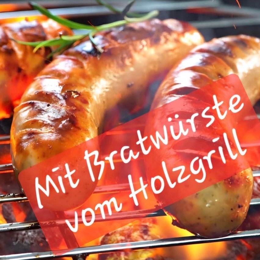 A close-up view of sausages being grilled on a wood-fired grill, with the text 'Mit Bratwurste vom Holzgrill' overlaying the image.