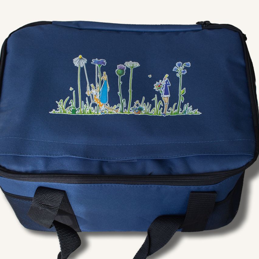 Eine blaue Tasche mit einer bunten Illustration einer Gartenszene mit Blumen und zwei Figuren, eine hält einen Blumenstrauß und die andere gießt Pflanzen.