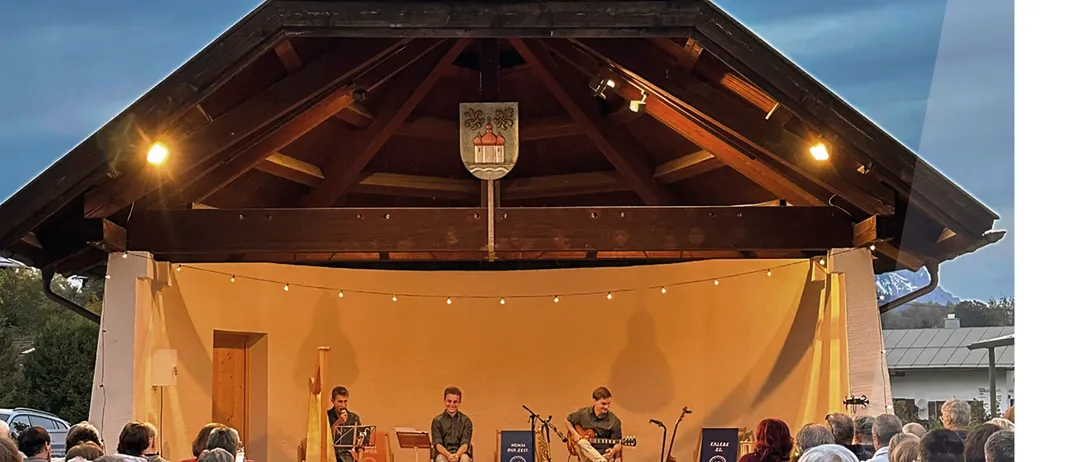 Werbeposter für ein Konzert mit Dreiklang. Drei Musiker spielen auf der Bühne. Das Ereignis ist für den 20. September 2026 von 18:00 bis 19:00 Uhr geplant.