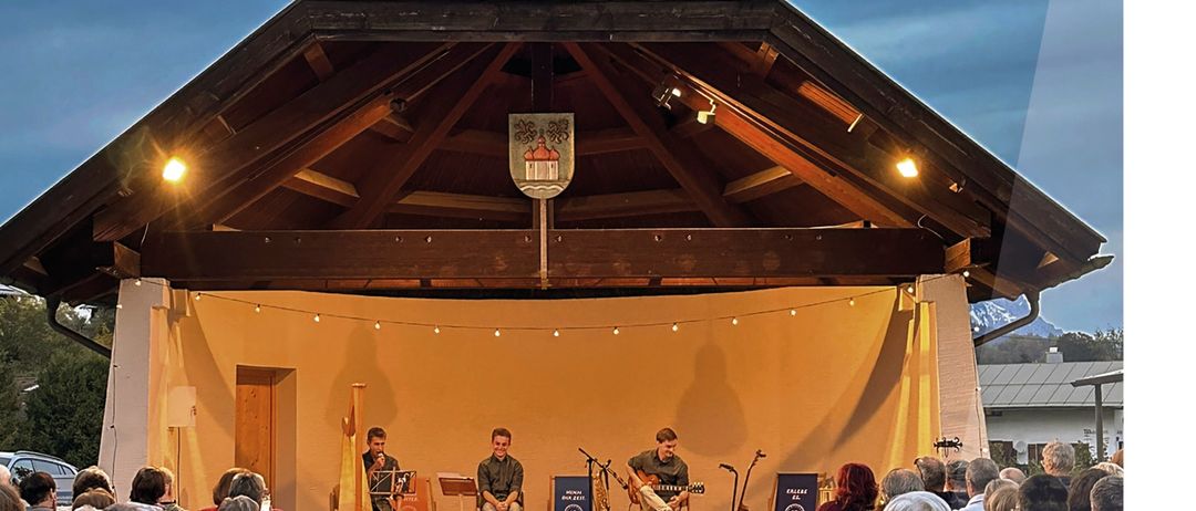 Werbeposter für ein Konzert mit Dreiklang. Drei Musiker spielen auf der Bühne. Das Ereignis ist für den 20. September 2026 von 18:00 bis 19:00 Uhr geplant.