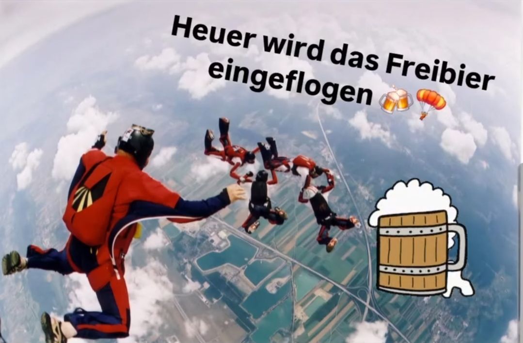 Fallschirmspringer in roten Anzügen, in der Luft, einer hält einen Helm. Der Himmel steht 'Heuer wird das Frei eingeflogen'. Eine Bierkanne mit Schaum und einem Fallschirmsymbol ist in der Ecke.