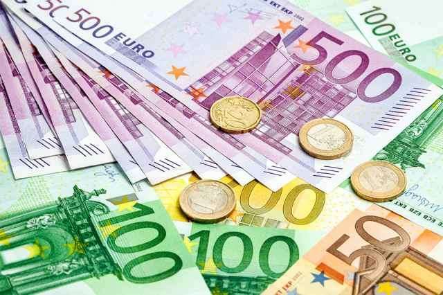 Euro-Banknoten und -Münzen in verschiedenen Stückelungen, einschließlich 500, 100 und 50 Euro, in einer ungeordneten Anordnung gezeigt.