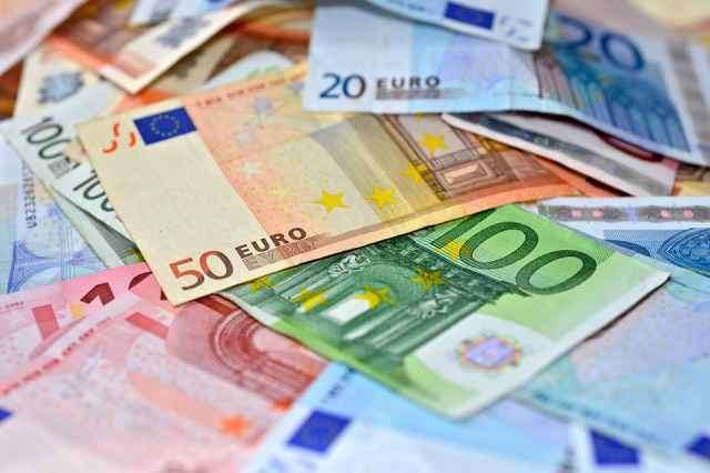 Ein Haufen von Euro-Banknoten in verschiedenen Stückelungen, einschließlich 100, 50, 20 und 10 Euro, verstreut auf einem Tisch.