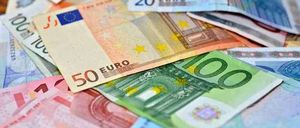 A pile of Euro banknotes in various denominations, including 100, 50, 20, and 10 euros, scattered on a table.
