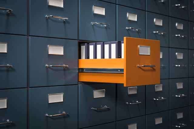 Ein Schrank mit mehreren Ordnern, von denen einer geöffnet ist und Dateien darin zeigt.