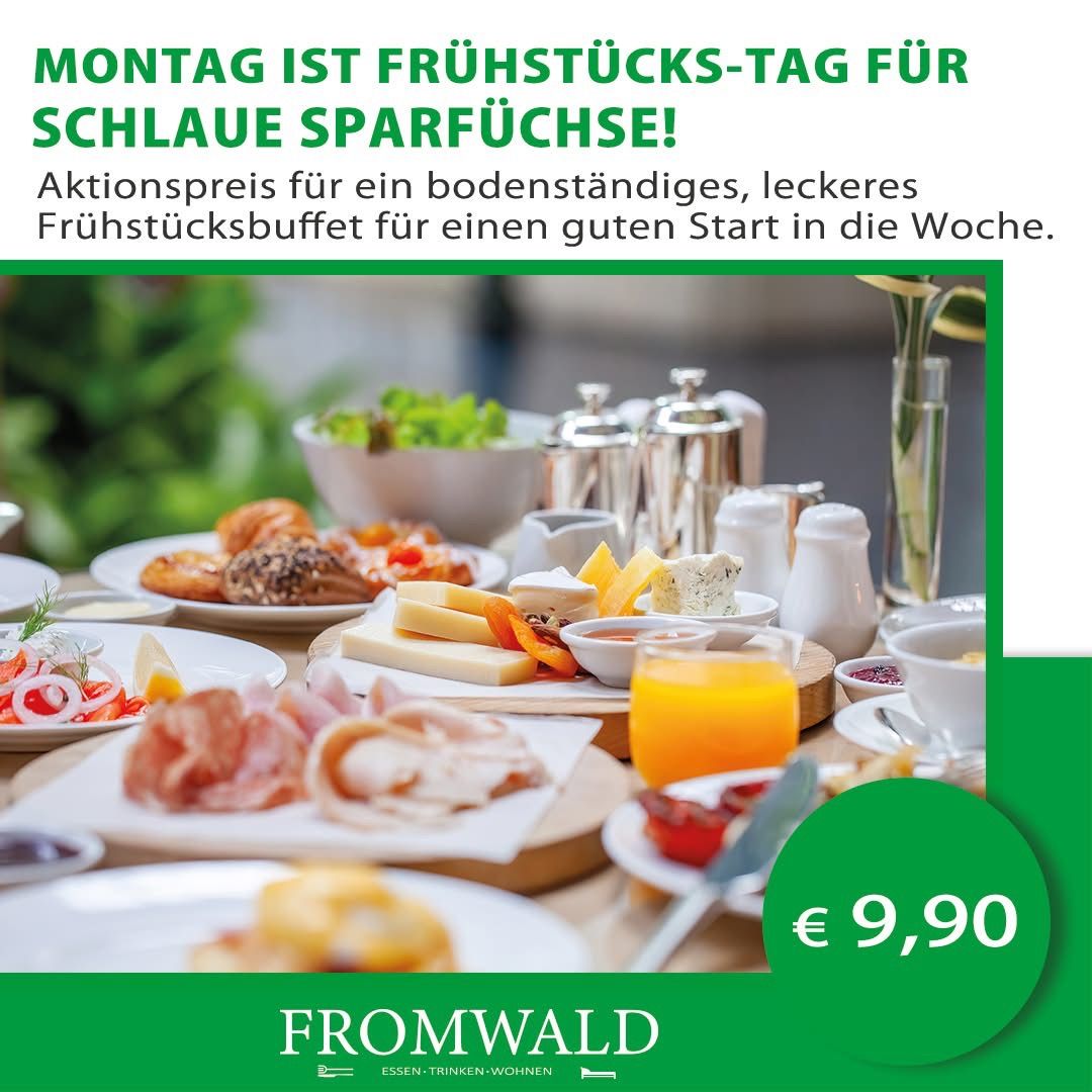 Werbung für ein Frühstücksbuffet mit einem Preisschild von 9,90 Euro. Ein Tisch ist mit Tellern verschiedener Speisen gedeckt, darunter Brot, Käse und Gemüse. Es gibt auch Gläser mit Saft und Kaffee. Die Werbung ist auf Deutsch geschrieben.