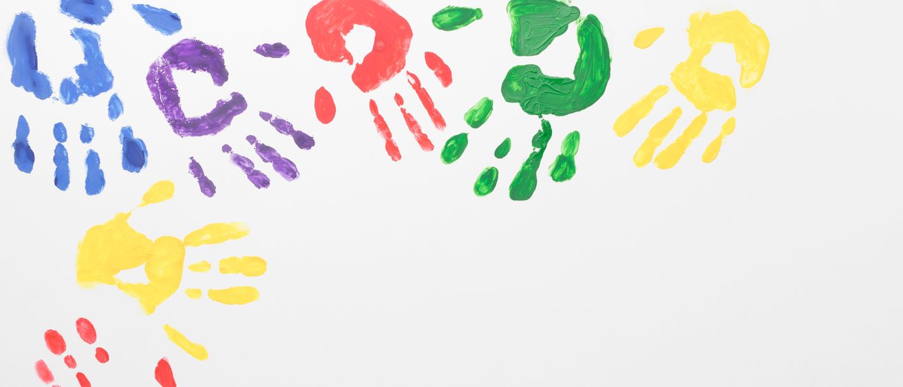 Eine Reihe von bunten Handabdrücken in Rot, Gelb, Grün, Lila und Blau auf weißem Hintergrund gemalt.