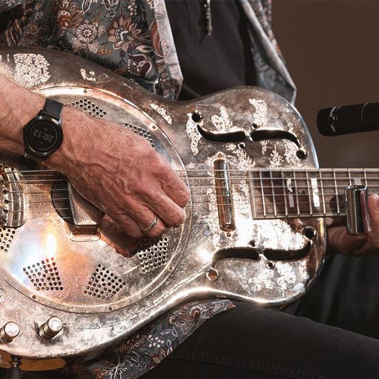 Bild enthält, Guitar, Musical Instrument, Guitarist, Music, Musician, Performer, Person, Microphone, Wristwatch, Candle