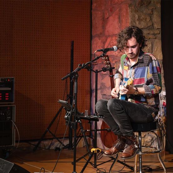 Bild enthält, Performer, Person, Solo Performance, Music, Musical Instrument, Musician, Guitar, Guitarist, Shoe, Singing