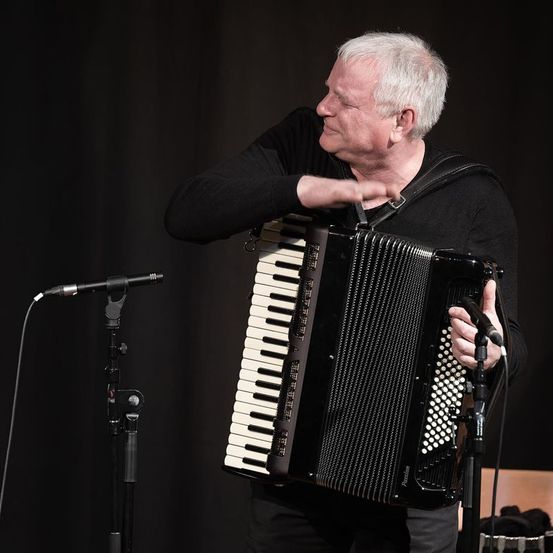 Bild enthält, Adult, Male, Man, Person, Electrical Device, Microphone, Musical Instrument, Solo Performance, Face, Accordion