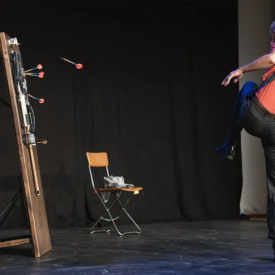 Performer, Person, Solo Performance, Chair, Furniture, Crossbow, Weapon
