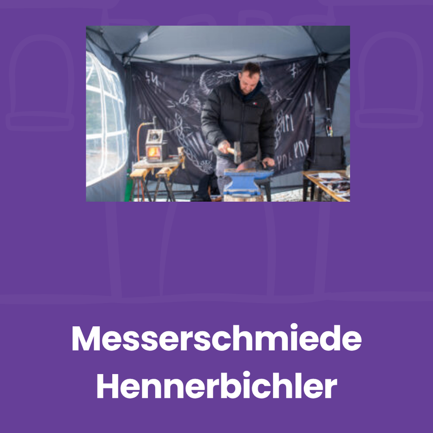 Ein Mann in einer schwarzen Jacke hämmert auf einen Metall Amboss in einem Zelt mit einem Banner dahinter.