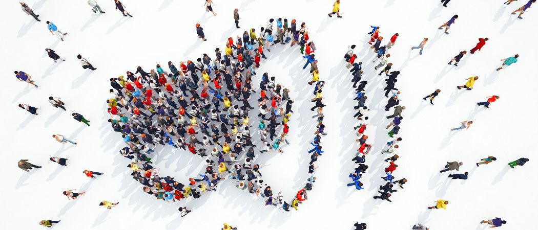 Eine große Menschenmenge bildet ein Herz auf einem weißen Hintergrund. Viele Personen gehen in verschiedene Richtungen.