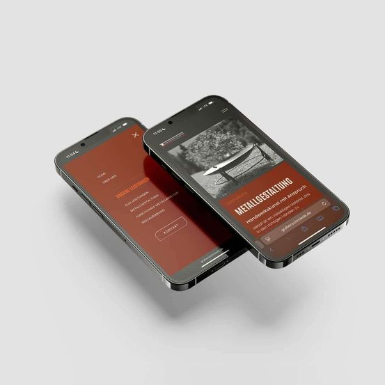 Zwei Smartphones zeigen eine Website auf ihren Bildschirmen. Das linke Telefon zeigt eine Startseite, während das rechte Telefon eine Seite mit dem Wort 'METALLGESTELLEN' und einem Bild eines Metallobjekts anzeigt.