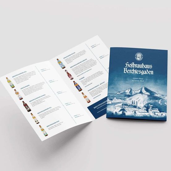 Eine offene Broschüre mit einem blauen Cover, das den Namen 'Sofbrauhaus Berchtsgaden' und eine Berglandschaft zeigt. Die Broschüre enthält Beschreibungen verschiedener Biere.