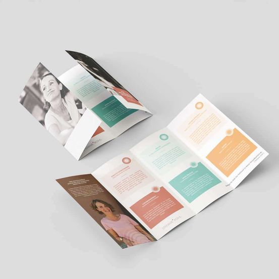 Zwei Broschüren mit modernem Design. Eine ist geöffnet und zeigt Text, die andere ist gefaltet mit einem Frauenfoto. Beide haben mehrfarbige Abschnitte.