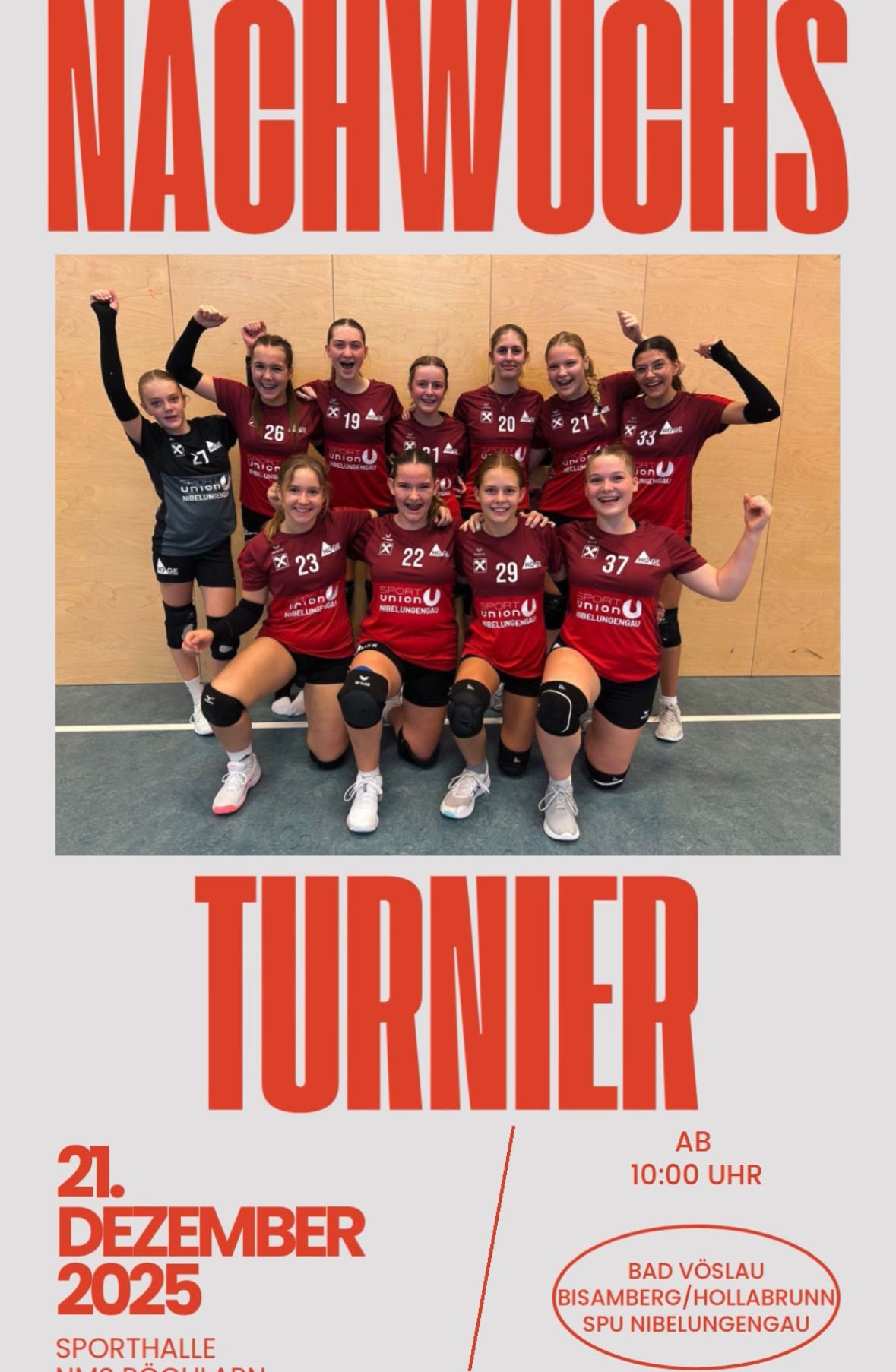 Eine Gruppe weiblicher Volleyballspielerinnen in roten Trikots mit Nummern posiert fröhlich für ein Foto.