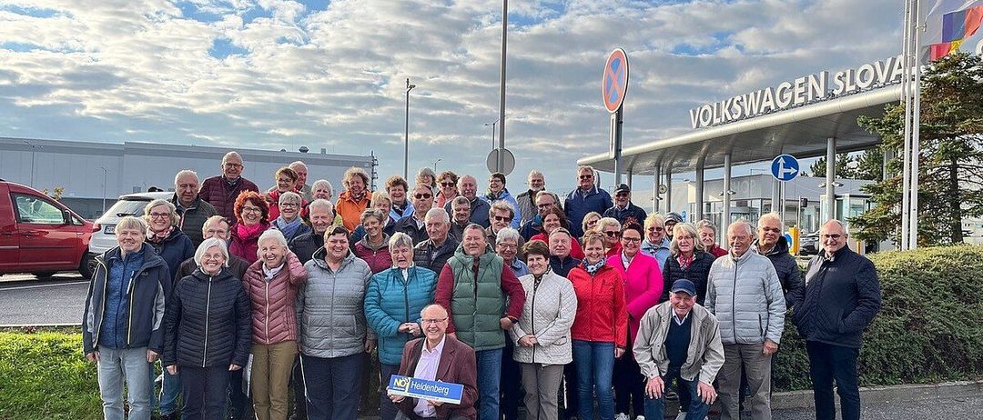 Eine große Gruppe von Menschen steht vor dem Volkswagen-Werk. Sie sind warm gekleidet für das kalte Wetter.