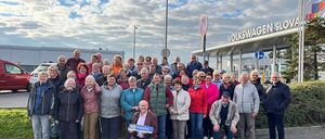 Eine große Gruppe von Menschen steht vor dem Volkswagen-Werk. Sie sind warm gekleidet für das kalte Wetter.