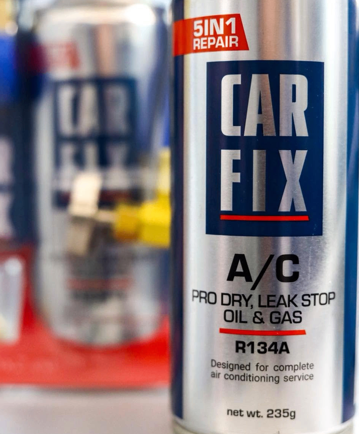 Eine silberne Dose CAR FIX A/C PRO DRY, LEAK STOP OIL & GAS, R134A ist zu sehen, entwickelt für Klimaanlagenwartung.