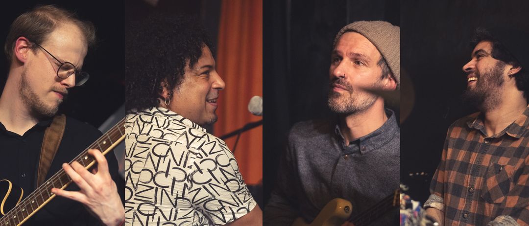 Three musicians perform, one plays guitar, another with a beanie, and the third smiles and holds a guitar. They are in a dimly lit room.