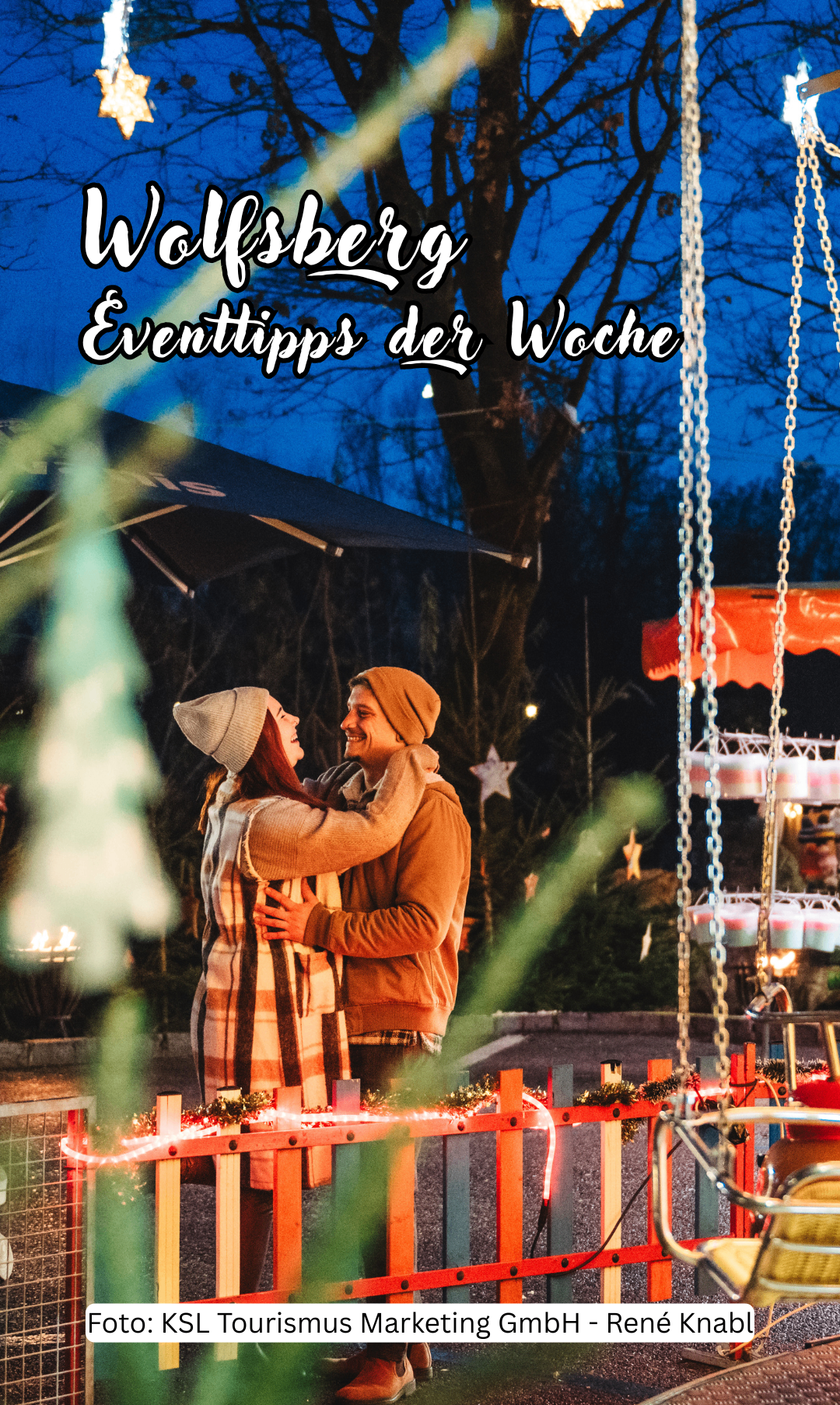 Ein Paar, das sich unter einem Weihnachtsbaum umarmt, in einer festlichen Außenumgebung. Sie lächeln und der Bereich ist mit Lichtern und Ornamenten geschmückt.